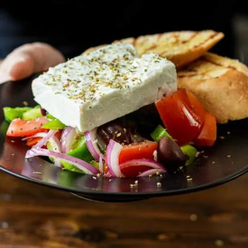 greek salad on a plate with feta and oil